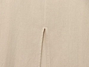 Détail de la robe midi en lin avec fente latérale et texture tissée naturelle