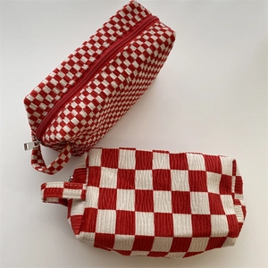 Red and white checkered corduroy makeup bag detail with metal zipper and handle strap
