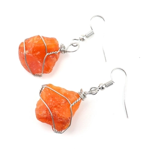 Detail of handmade silver wire wrapped natural orange raw stone drop earrings for women