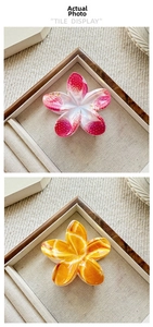 Close-up of strawberry and orange pattern floral hair claws on a rustic wooden tray