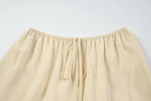Detailed close-up of the beige elastic waistband with adjustable drawstring tie