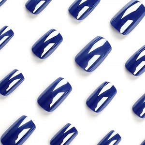 Faux ongles carrés bleu marine brillant disposés en un alignement diagonal élégant