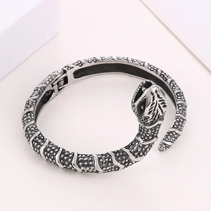 Close-up of vintage silver snake bangle showing detailed scale textures and engraved head