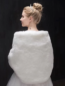 Detail shot of the back of a luxurious white faux fur bridal shawl for winter weddings