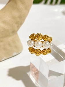 Macro shot of three-layer beaded stainless steel ring with white pearls and gold beads