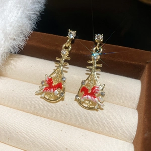 Macro shot of gold lute-shaped earrings with rhinestones and Pegasus motif on velvet