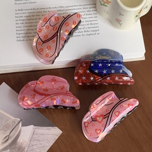 Vintage acrylic hair claws with pearlescent heart and cherry patterns on wooden table