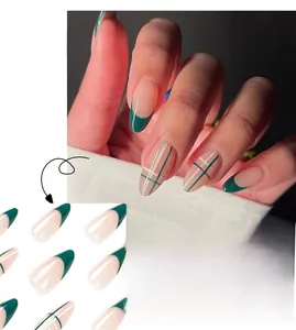 Detail view of long almond press-on nails with dark green french tips and plaid pattern