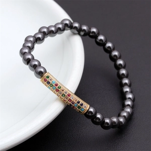 Close-up of hematite beaded bracelet with a gold tube set with colorful zircons