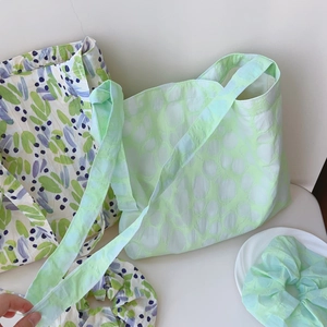 Detail of floral and textured tote bags with matching scrunchies on a white desk