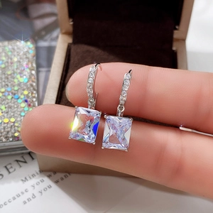 Macro view of rectangular cubic zirconia earrings on fingertip with silver finish