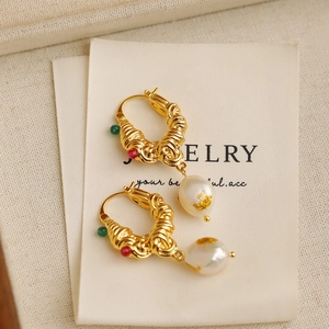 Macro view of vintage gold textured hoops with baroque pearls and gold leaf accents