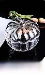 Close-up of a pumpkin-shaped crystal glass storage jar with a lid on a glossy surface