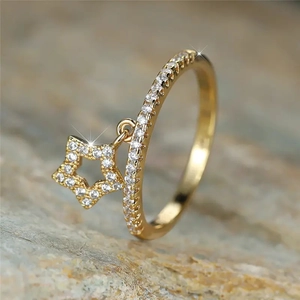 Elegant 18K gold star charm ring with shimmering zircon stones on a natural stone base