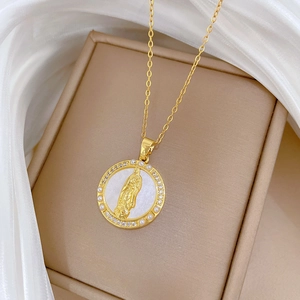 Detailed close-up of gold medallion pendant with mother of pearl and crystal accents