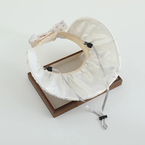 Détail d'un chapeau de soleil à fleurs avec dentelle et cordon réglable pour enfants