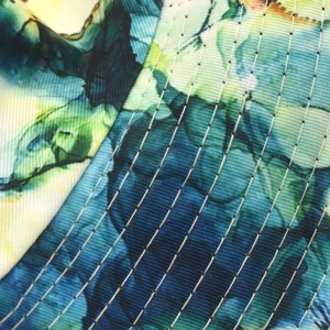 Macro view of colorful floral print fabric with high-density parallel quilting stitches