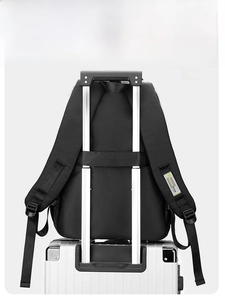 Detail of black backpack with integrated luggage strap secured on a suitcase handle
