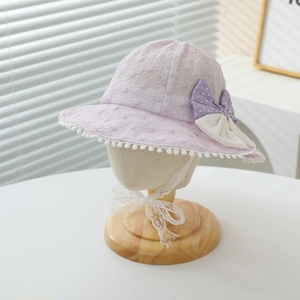 Detailed view of a baby girl's purple lace sun hat featuring a cute polka dot bow