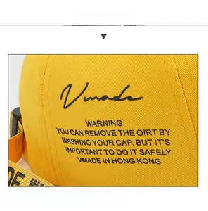 Detail of yellow cotton baseball cap with Vmade logo and printed adjustable strap
