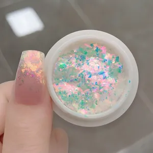 Close-up of iridescent aurora opal nail powder and sparkling manicure effect