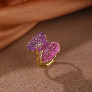 Detail of gold open ring with purple and pink crystal hearts and a tiny star zircon