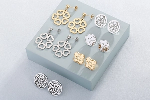 Macro view of gold and silver hollow heart earrings and floral stud earring collection