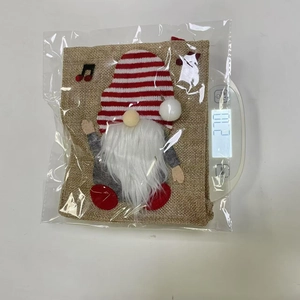 Christmas burlap gift bag with gnome motif showing product weight on a digital scale