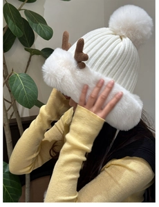 Detail of white knit winter hat with reindeer antlers and soft faux fur lining