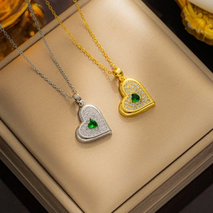 Close-up of heart-shaped pendant necklace with emerald green gemstone and pavé stones