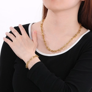 Polished gold infinity link necklace and bracelet set worn by a male model