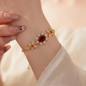 Vintage gold bracelet with oval red zircon centerpiece and floral accents for women