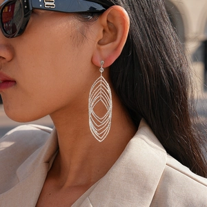 Chic silver geometric hollow oval layered clip-on earrings worn by a model in sunlight