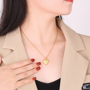 Close-up of golden twist chain with heart pendant and center zircon on model neck