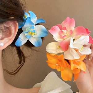 Détail d'épingles à cheveux en tissu fleuri aux tons bleu, rose et orange vif