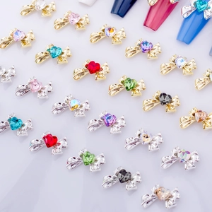 Bowknot nail art charms with heart crystals in multiple colors and metallic finishes