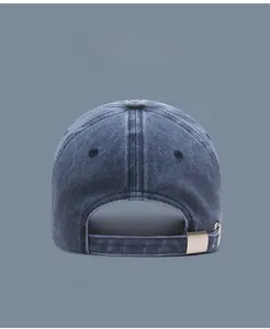 Detail view of the adjustable metal buckle and back strap on a washed denim baseball cap