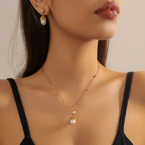 Vintage gold stainless steel necklace and earrings set with elegant pearls on model