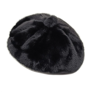Detail of the plush black faux fur texture and top pom-pom on the winter beret hat