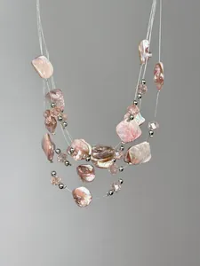Detail of pink baroque shell shards and crystal beads on a multi-layer necklace