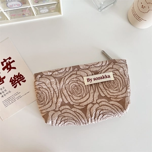 Detailed view of khaki French embossed rose texture on a portable cosmetic storage bag