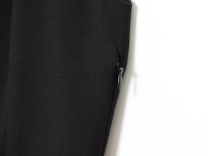 Close-up of invisible zipper closure on black woven fabric mini blazer dress