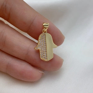 Detail of a gold plated Hamsa Hand pendant with cubic zirconia inlay and polished finish