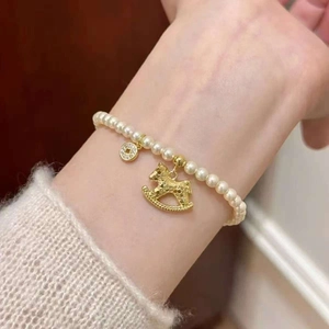 Bracelet de perles élégant avec breloque cheval à bascule dorée et pièce au poignet
