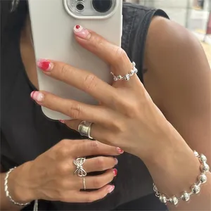 Detail view of 925 sterling silver beaded rings and bracelets worn by a model
