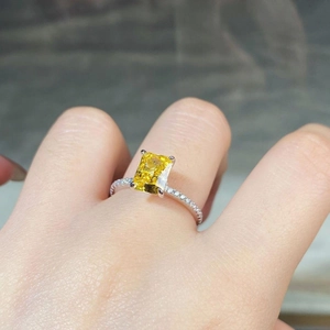Detailed macro shot of a yellow rectangular-cut zircon ring with silver pavé band