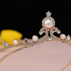 Close-up of golden crown with white pearls and sparkling rhinestones detailing