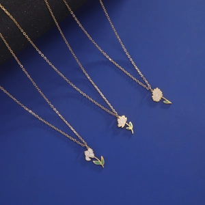 Detailliertes Set aus drei goldenen Halsketten mit Emaille-Blumen auf blauem Hintergrund
