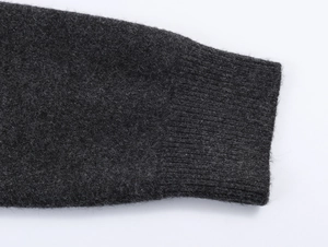 Detailed macro view of charcoal grey knit cardigan cuff with premium wool ribbing texture