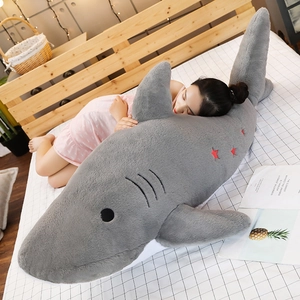 Macro view of giant shark plush toy featuring grey fabric and red star embroidery